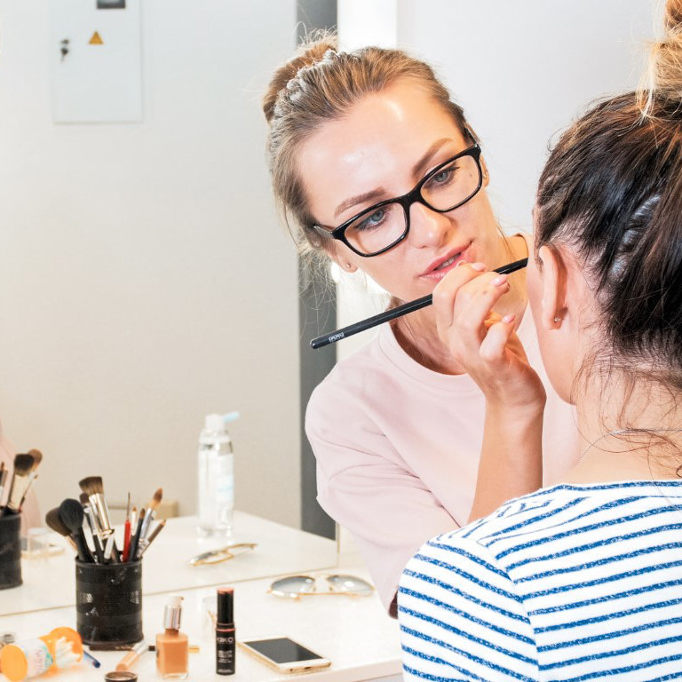 Professional makeup artist teaching students in makeup studio